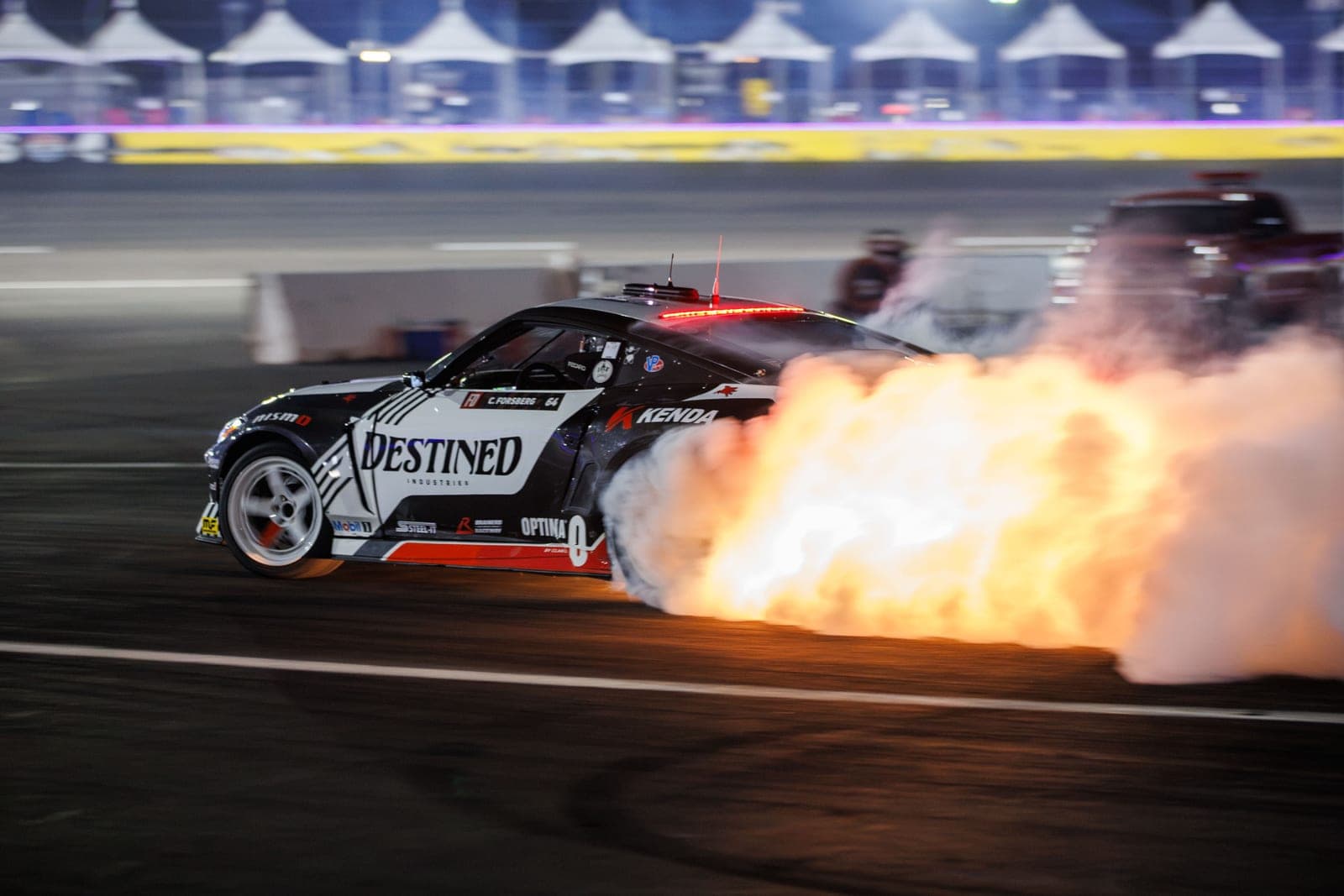 Chris Forsberg's Destined Industries Nissan Z drifting under the lights at the Las Vegas Motor Speedway Bullring